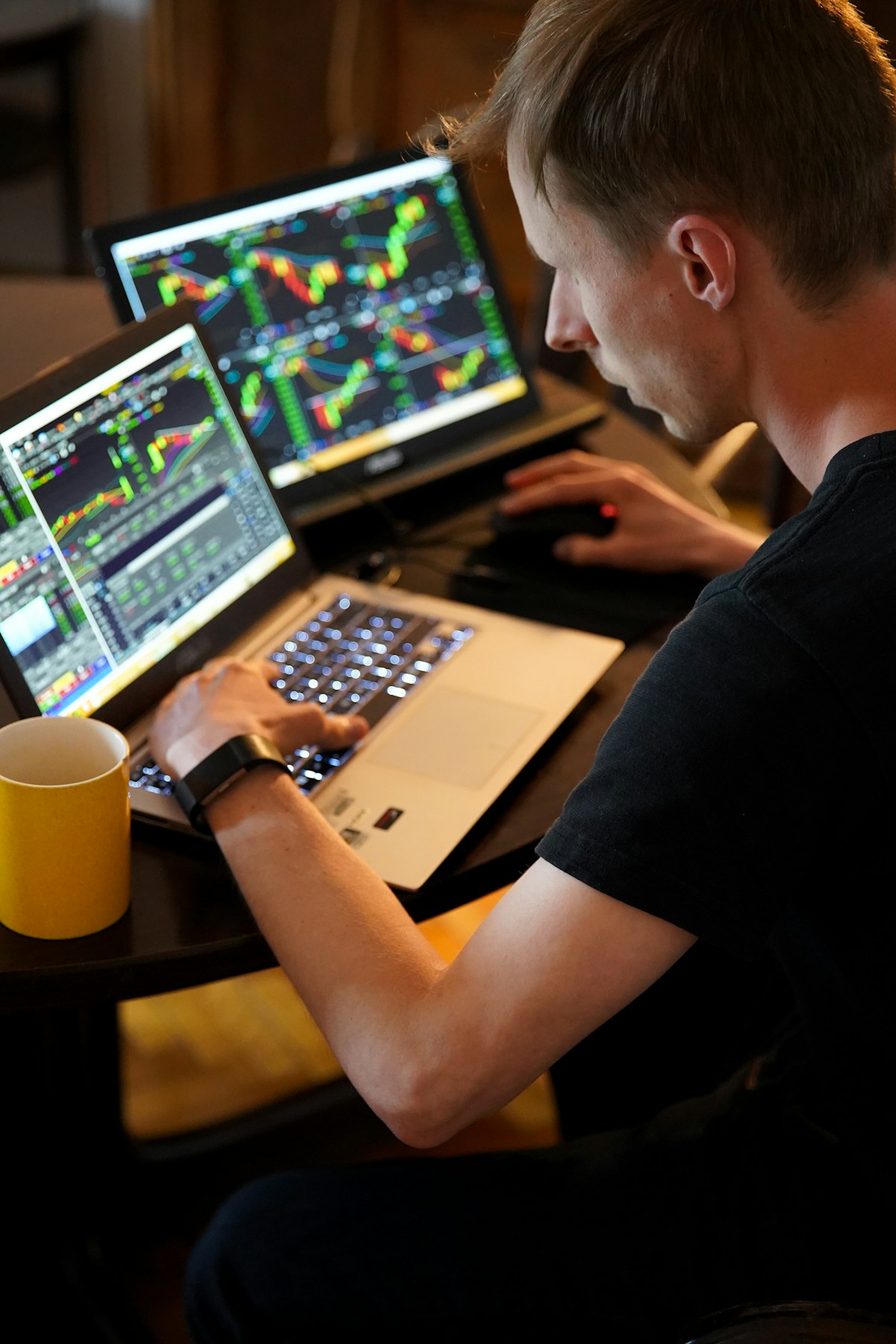 Pessoa analisando gráficos de trading em várias telas